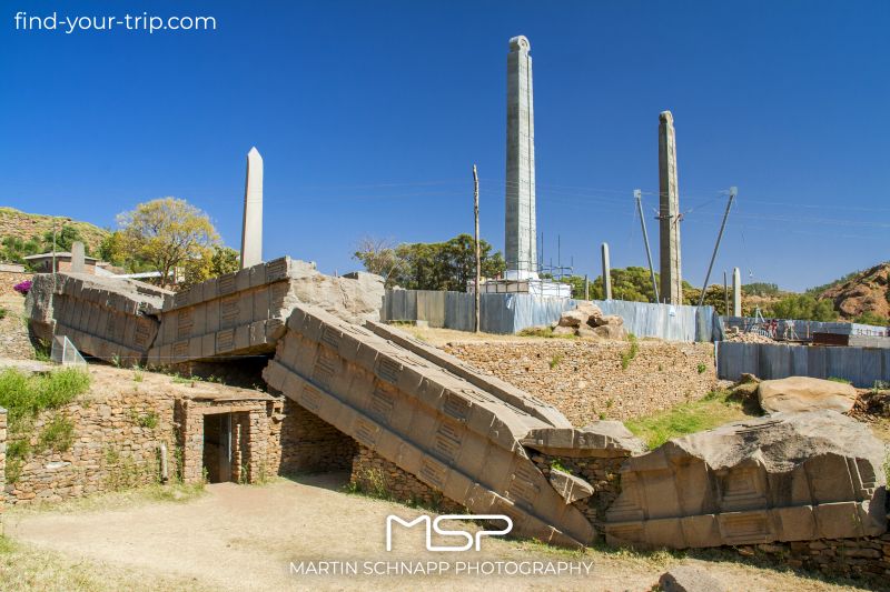 The <b>Park of Stelae (May Hedja) of Aksum</b> in <b>Ethiopia</b> with carved monolithic stone columns up to 33 meters long was the cemetery of the pre- and early Christian rulers of Aksum. In front stele 1 (overturned) (33.3 meters, approx. 520 tons), behind it stele 2 (24.6 meters, 170 tons), to the right of it stele 3 (with base 23.6 meters at an estimated 160 tons). <a href='https://find-your-trip.com/?t=guide&poi=et8751&lang=en' target='fyt'><nobr>[ ⭢	map ]</nobr></a>