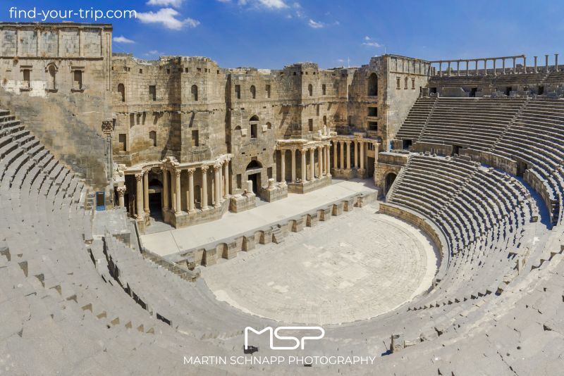 The <b>Roman Theater of Bosra</b> in <b>Syria</b> was built in either the second quarter or second half of the second century AD and is made of black basalt. It is likely that the theater was built during the reign of Trajan. <a href='https://find-your-trip.com/?t=guide&poi=sy6985&lang=en' target='fyt'><nobr>[ ⭢	map ]</nobr></a>